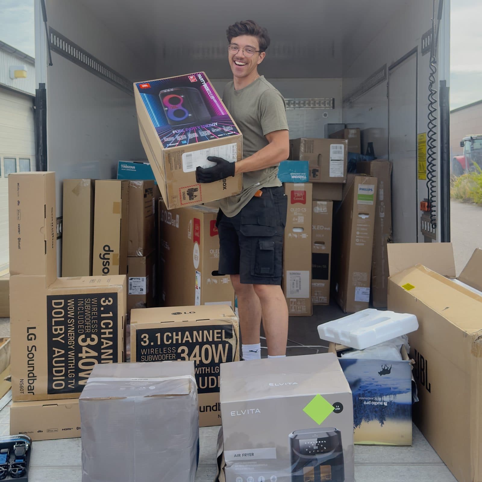 Rewind unloading saved home electronics from a water-damaged store — TVs, speakers and appliances on their way in for claims verification